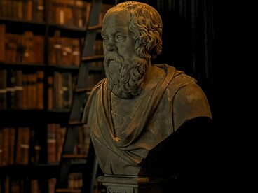 A statue of Socrates framed by shelves of books, reflecting the centuries-old pursuit of knowledge through written works