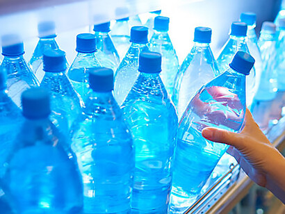 In the context of ongoing discussions on the privatization of water, an image portrays a consumer opting for bottled water from a store shelf, underscoring the reliance on commercialized options in addressing personal hydration needs