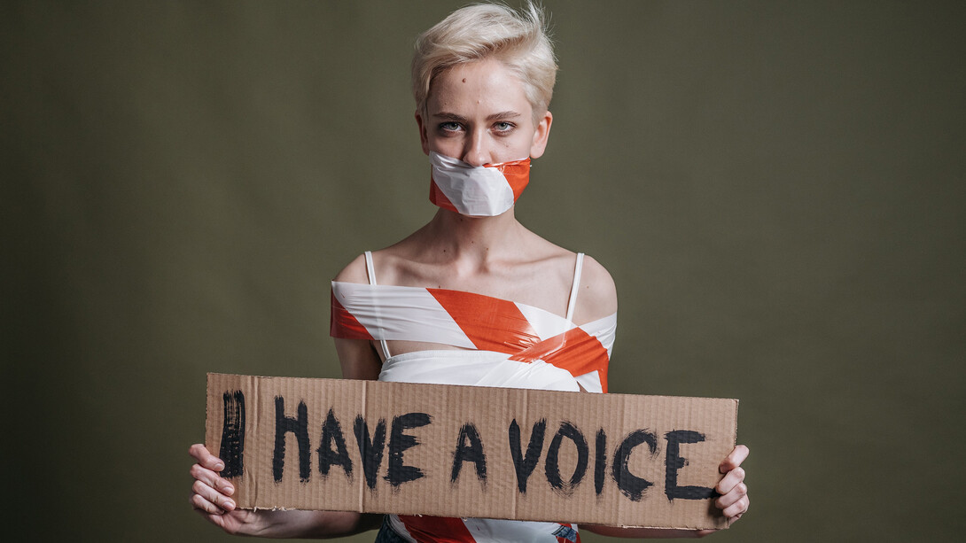 Una giovane donna mostra la scritta “Io ho una voce”