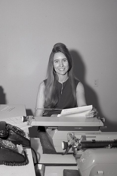 Secretaria en su escritorio con varias máquinas de escribir