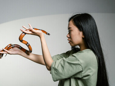 A woman overcoming her fear of snakes — illustrating the moment when fear transforms into strength and resistance gives way to growth