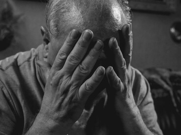 Sentado e com as mãos cobrindo o rosto, um homem demonstra sofrimento emocional. O luto, a negação e a angústia são algumas das reações humanas diante da perda e da finitude