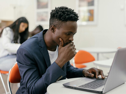 Focused student working on a laptop in a modern classroom environment