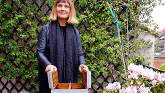 Claudia Zanfi con un'arnia sul terrazzo di casa