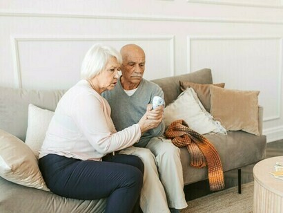 Die Frau gibt älteren Menschen mit Alzheimer die Temperatur zurück