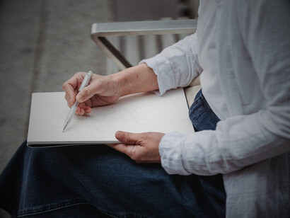 An artist drawing, hinting at the human vision behind bold and controversial stylistic choices