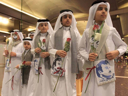 Niños qatarís con flores e imágenes del emir Al Thani reciben a ciudadanos de Kuwait y Omán, países que no se han sumado al boicot