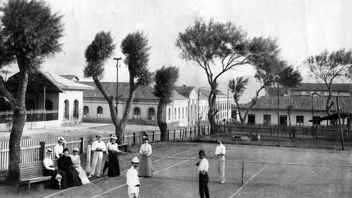 Escena en la ciudad de Cartago, Costa Rica, hacia 1904. Al fondo, al centro, el edificio antiguo del Colegio de San Luis Gonzaga; a la izquierda, parte del mercado y, en primer plano, miembros de la familia Pirie disfrutando de un partido de tenis. Todos los edificios visibles aquí fueron destruidos, a causa del terremoto de 1910. Foto de Paynter Brothers, propiedad y cortesía de Fraser Pirie Robson