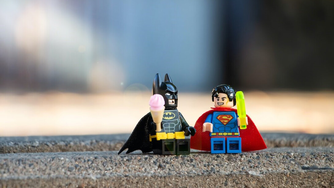 Superman and Batman action figures joined in friendship, holding hands