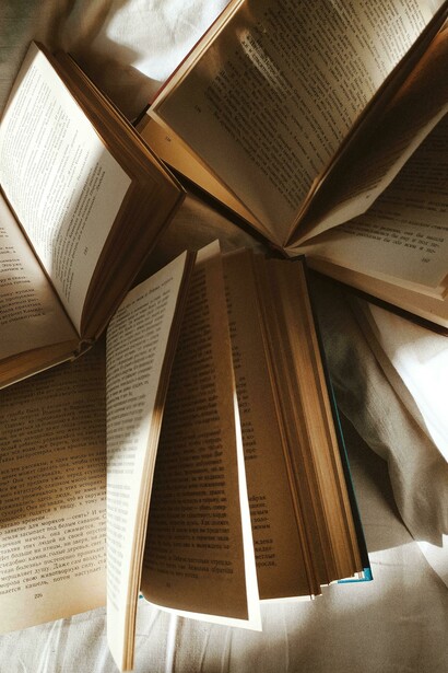 Libros abiertos en distintas páginas repartidos sobre una cama. Con las múltiples posibilidades del lenguaje, hay quienes lo emplean para malversar la reputación de las personas