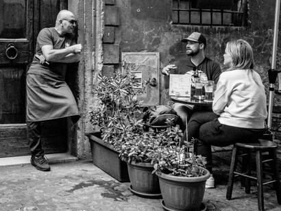 The two travellers chat with the local waiter, the vibrant exchange of cultures makes every meal a deeper experience in understanding the heart of a place