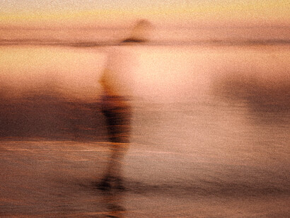 Figura en movimiento barrido o barrido cinético en la orilla de una playa con tonalidades doradas y anaranjadas al atardecer