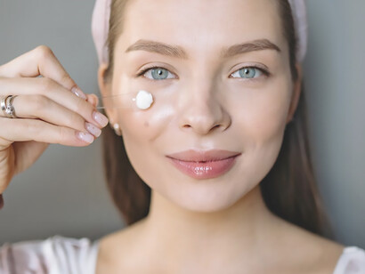 Witness the beauty of a woman pampering her skin with essential skincare routine steps, delicately applying cream for a radiant complexion