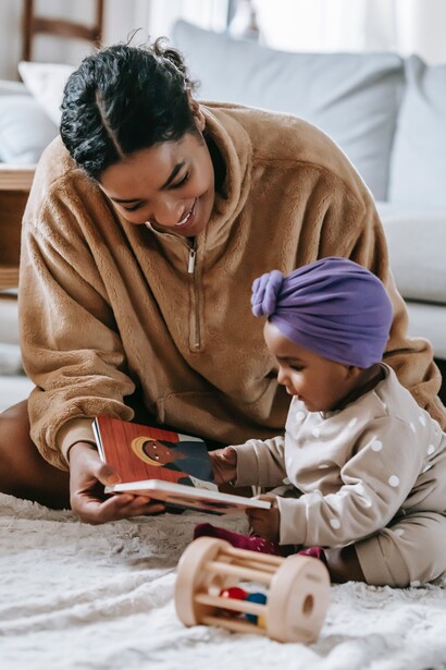 A mother reading a book to a child. Material possessions do not necessarily create happiness 