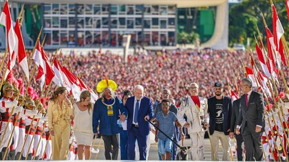 Luiz Inácio Lula da Silva sobe a rampa do Palácio do Planalto para assumir pela terceira vez a Presidência da República, acompanhado por representantes de diferentes segmentos da sociedade brasileira. A cena simboliza uma democracia que busca devolver ao espaço do poder a diversidade de vozes que compõem o país. Diante da ausência do ex-presidente para passar a faixa presidencial, a cerimônia organizou esse grupo para representar a diversidade, as minorias sociais e a riqueza cultural do povo brasileiro. O ato simbolizou que o poder estava sendo devolvido diretamente "pelas mãos do povo". Janja Lula da Silva: Primeira-dama do Brasil. Foi a idealizadora do formato do cortejo para trazer protagonismo à sociedade civil. Lu Alckmin: Segunda-dama do Brasil, esposa do vice-presidente Geraldo Alckmin. Cacique Raoni Metuktire: Uma das lideranças indígenas mais influentes e reconhecidas do mundo. Representa a luta dos povos originários, a demarcação de terras indígenas e a preservação da Floresta Amazônica. Jucimara Fausto dos Santos (Aparece parcialmente atrás, entre Raoni e Lula): Ela é uma cozinheira paranaense que cozinhou na "Vigília Lula Livre" durante os 580 dias de prisão do presidente. Representa as lutas sociais e a culinária popular. Luiz Inácio Lula da Silva: O presidente eleito e empossado. Francisco Filho (10 anos): Estudante e morador de Itaquera (São Paulo), corintiano e atleta de natação. Representa a infância brasileira, as periferias urbanas e o futuro do país. Flávio Pereira (Homem de cabelos e barba grisalhos que aparece logo atrás do menino Francisco): Artesão e artista plástico, natural do Paraná, ele também esteve ativamente na vigília e ajudou a organizar o cotidiano do acampamento. Resistência: A cadelinha vira-lata que foi adotada por Janja enquanto Lula esteve na prisão em Curitiba. Simboliza a causa da proteção animal e os direitos dos animais de estimação. Ivan Baron: Influenciador digital do Rio Grande do Norte que tem paralisia cerebral. Representa a luta anticapacitista e a inclusão social de pessoas com deficiência. Weslley Viesba Rodrigues Rocha: Metalúrgico do ABC Paulista que trabalha na região há anos. Representa a classe operária brasileira e a força dos trabalhadores, fazendo conexão direta com as origens sindicais do próprio Lula. Aline Sousa, a catadora de materiais recicláveis de 33 anos que colocou oficialmente a faixa em Lula, representando as mulheres negras e os trabalhadores informais