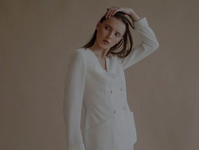Fashion portrait of a chic young woman in luxurious neutral-toned clothing
