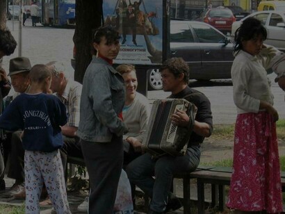Members of the Roma are out on the street trying to earn living with an accordion 