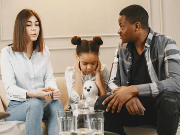 Parents and their little child participate in a family therapy session focused on trauma recovery and emotional support
