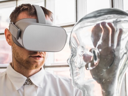 A young doctor using VR goggles examines a mannequin in a simulated environment, highlighting the future of medical technology and AI–human interaction