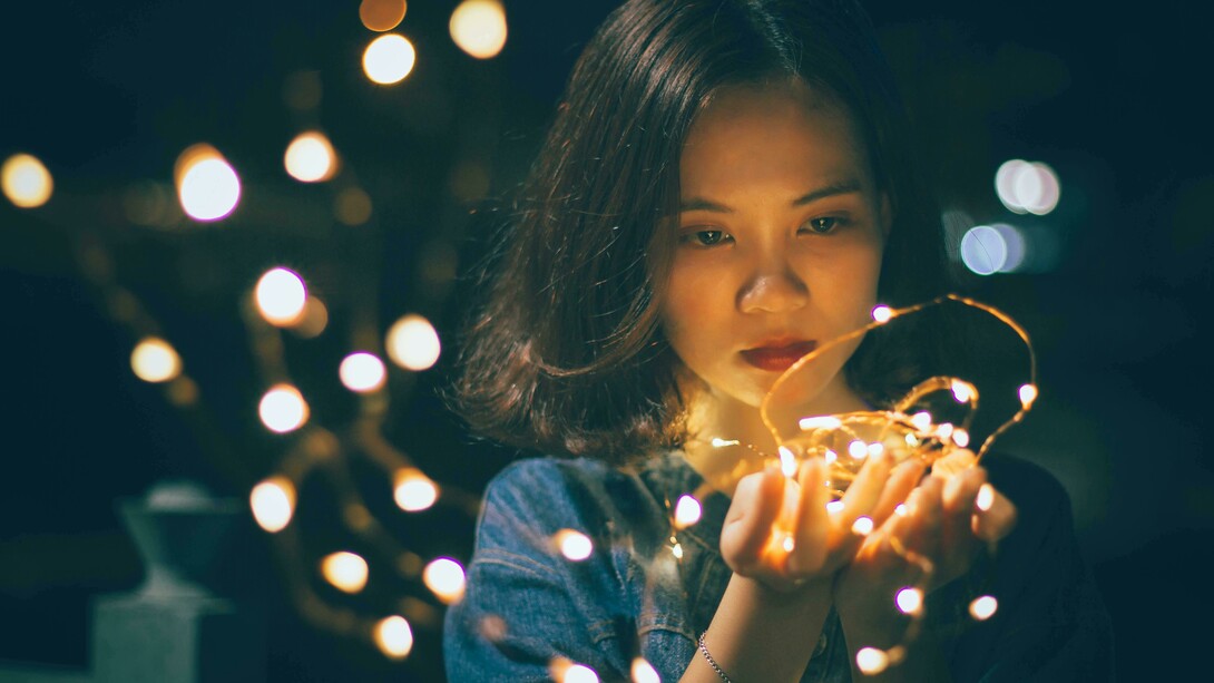 Donna con sguardo triste con luci di Natale. Il Natale e la solitudine: ricordi di festività passate e desiderio di appartenenza