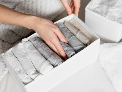 A woman decluttering her closet to create a minimalist and functional capsule wardrobe