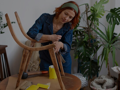 A female designer meticulously restores and crafts custom furniture, bringing an artistic touch to modern design