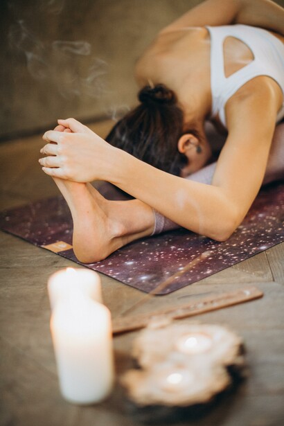 Person prioritising inner contentment by doing yoga with candles