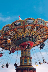 People enjoying a ride on a carousel at a theme park during the daytime