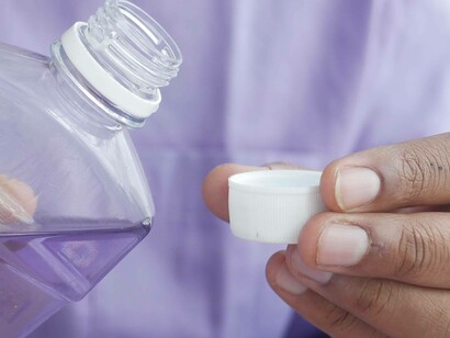 Man pours mouth wash into container