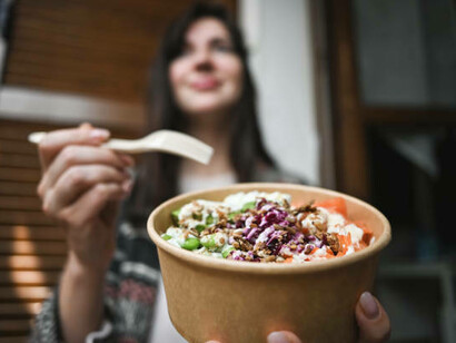 Enjoying a seafood salad in biodegradable, edible packaging, demonstrating a step towards more sustainable food packaging solutions