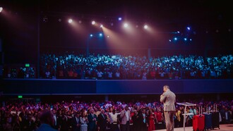 A man addressing a large gathering, showing how good leaders can effortlessly capture the attention and love of the followers
