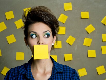 Una mujer rodeada de etiquetas para recordar cosas