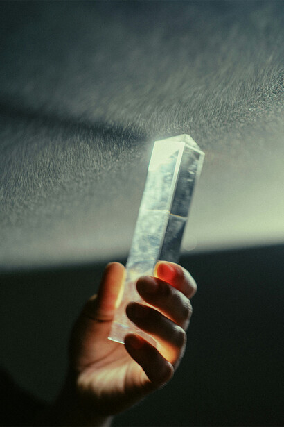 Mão segurando cristal que reflete a luz.
Conhecer as propriedades dos cristais é fundamental