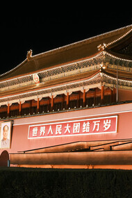 Night view of Tiananmen Gate in Beijing, where a large portrait of Mao Zedong hangs above its central arch