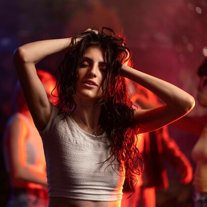 Una donna sta ballando, illuminata da luci rosse