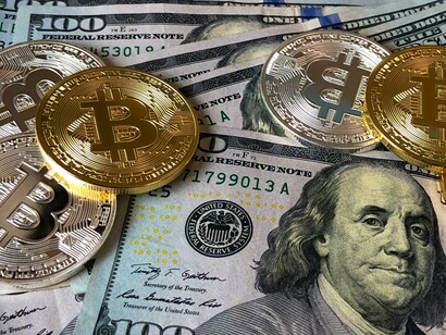 Bitcoins and US dollar bills. Investing allows for shared growth and wealth creation