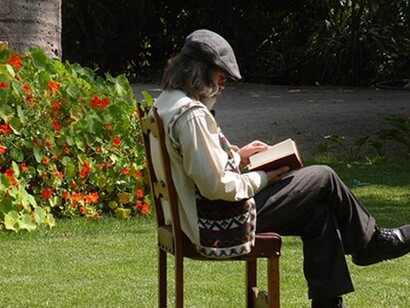 Un anciano leyendo en el jardín