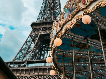 Torre Eiffel e carrossel em Paria, França. Estar em Paris é aprender a valorizar o que é bonito sem pressa: o simples gesto de sentar num banco e observar o mundo, de apreciar a luz dourada da tarde batendo nos telhados, de se perder e se encontrar num beco florido


