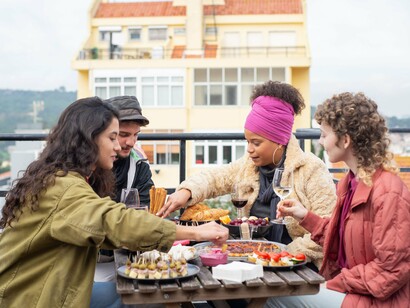 A diverse group connecting over food and conversation, symbolising the growing appeal of community-focused solo travel