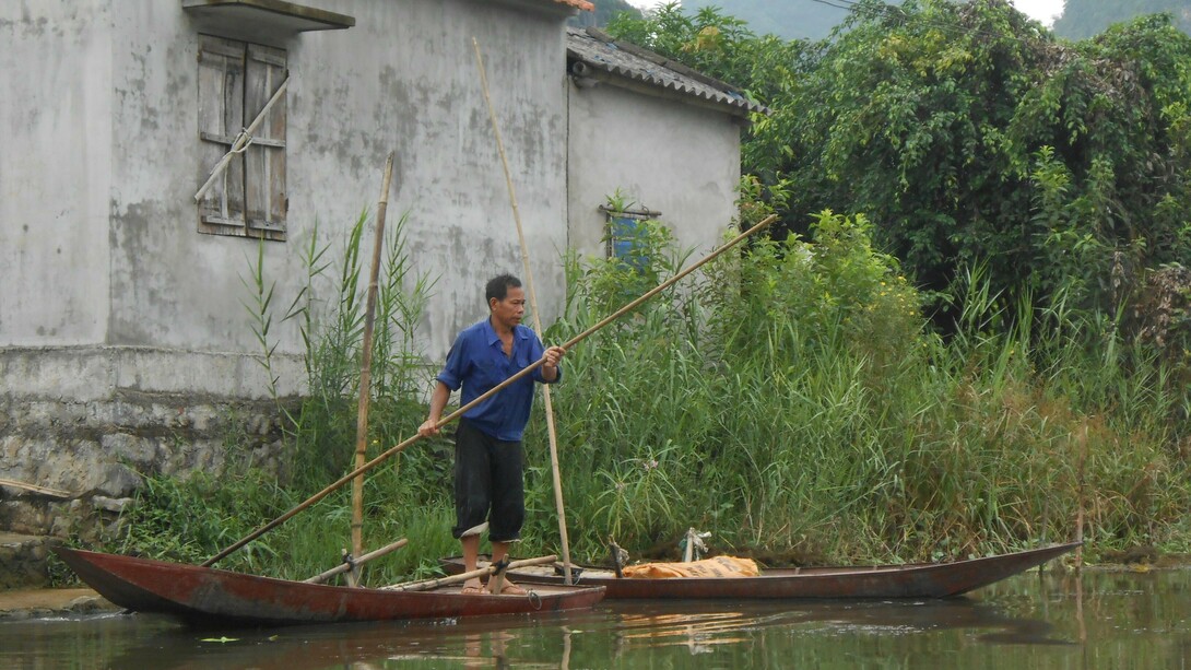 Vietnam. Vecino de Thung Nham remando en su pequeña embarcación
