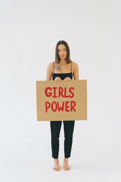 Uma mulher segurando um cartaz sobre o 'Poder feminino'