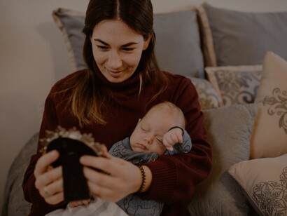 Mãe sorri com bebê no colo