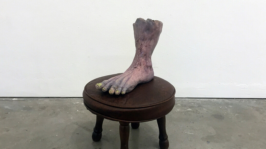 Woody Othello, Foot Rest, 2016, ceramic, underglaze, glaze, hair, epoxy coating resin and found foot rest, 18 x 12 x 12 inches. Courtesy of the artist.