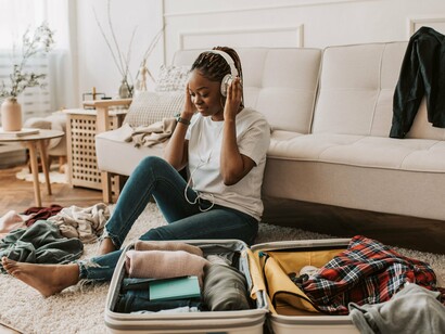 A woman taking a peaceful moment amid packing belongings, symbolising the emotional space between leaving what is familiar and embracing what lies ahead