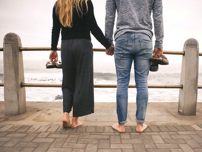 Pareja se toma de la mano mientras observa el oleaje