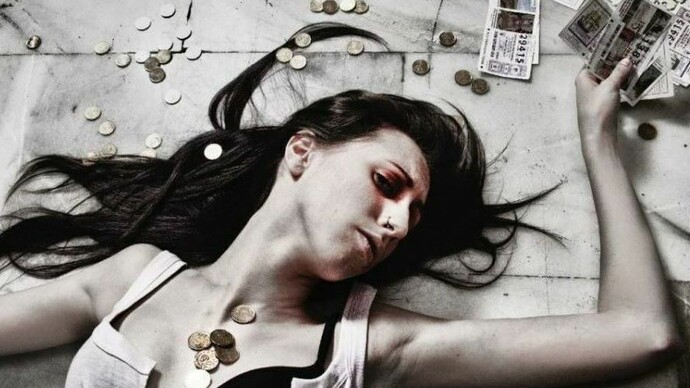 Mulher cercada por moedas e bilhetes de loteria