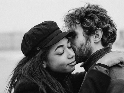 A man gently kisses his woman's cheek