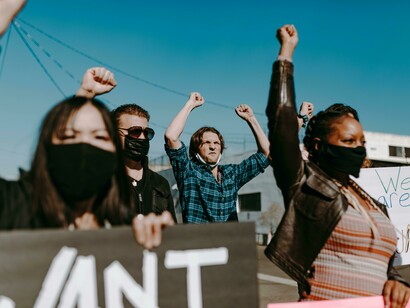 Young people walk down the street holding placards during a protest
