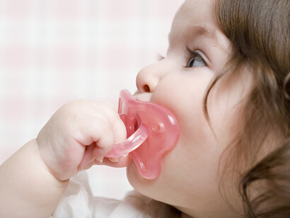 Una niña se pone su chupete