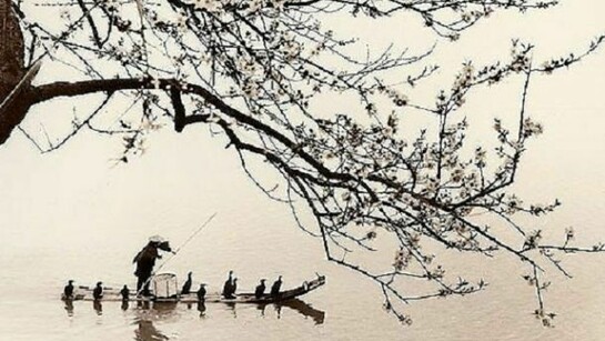 A Chinese fisherman crossing the water with his boat